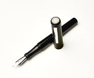 A Franklin-Christoph Model 03 Iterum Black & Creme fountain pen rests on a white background.