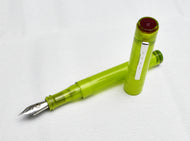 An uncapped Franklin-Christoph Model 03 Iterum in Frosted Olivae & Maroon sits on a white textured surface.