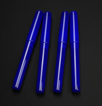Load image into Gallery viewer, Four glossy cobalt blue capped fountain pens arranged vertically on a dark black background.