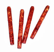 Load image into Gallery viewer, Four red and gold marbled resin pens arranged diagonally on a plain white background.