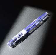 The Franklin-Christoph Model 66 Septagonal Italian Ice fountain pen glows on a dark, textured surface under bright light.