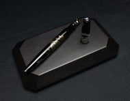 The Franklin-Christoph Model 66 Diamondback Dragon LE FP, uncapped, rests on dark wood with black and gold accents.