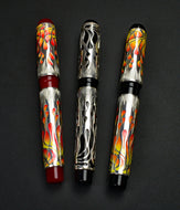 Four Franklin-Christoph Model 03M Fiamme di Christoph FP pens with flame designs are side by side on a dark background.