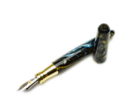 Franklin-Christoph Pocket 66 FP SE - Into the Void Brass, marbled blue/black/gold resin, metal nib, cap removed.