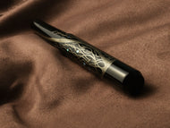 Franklin-Christoph Model 40 Panther Diamondtree LE FP rests on soft brown fabric, black and gold with intricate design.