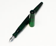 A Franklin-Christoph Model 65 Stabilis Fountain Pen in emerald rests uncapped on a white surface.