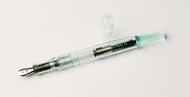 A transparent Franklin-Christoph Model 65 Stabilis pen, cap off, rests on antique glass acrylic.
