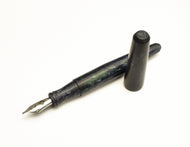 A Franklin-Christoph pocket 66 FP - matte EPW SE, black & silver, uncapped, rests on a white background.