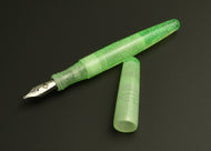 Franklin-Christoph pocket 66 Lime Sparkle FP prototype pen with silver nib and cap on a dark gray surface.